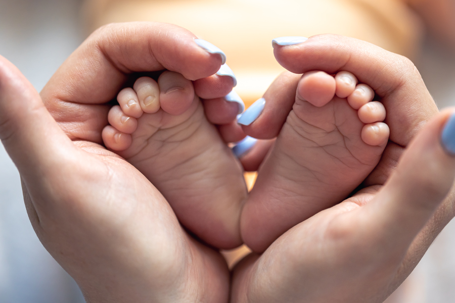 mom-holds-legs-newborn-baby-her-hands.jpg