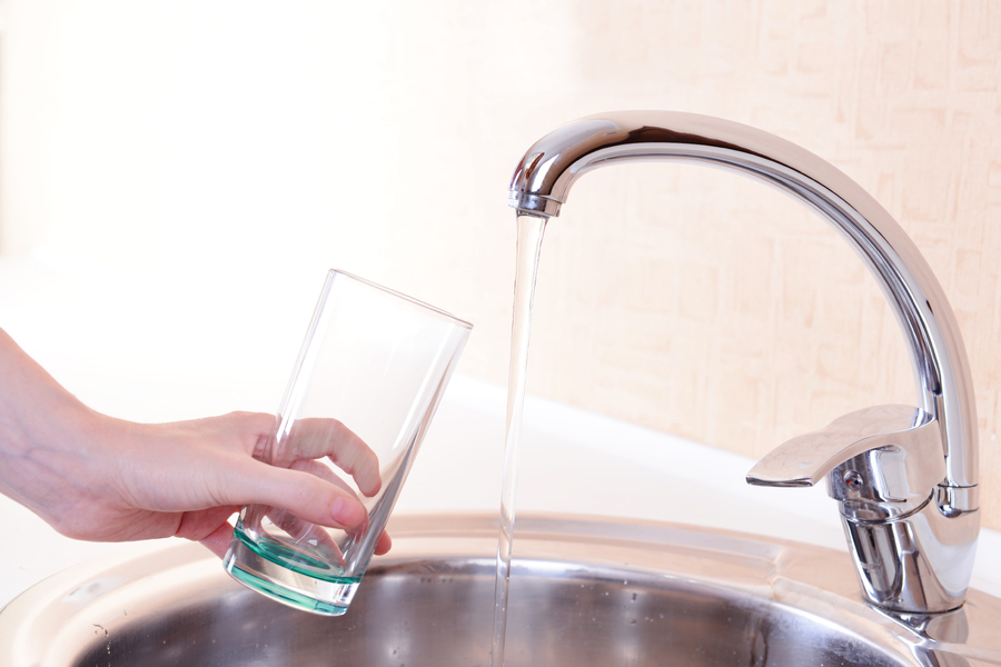 hand-holding-glass-water-poured-from-kitchen-faucet.jpg